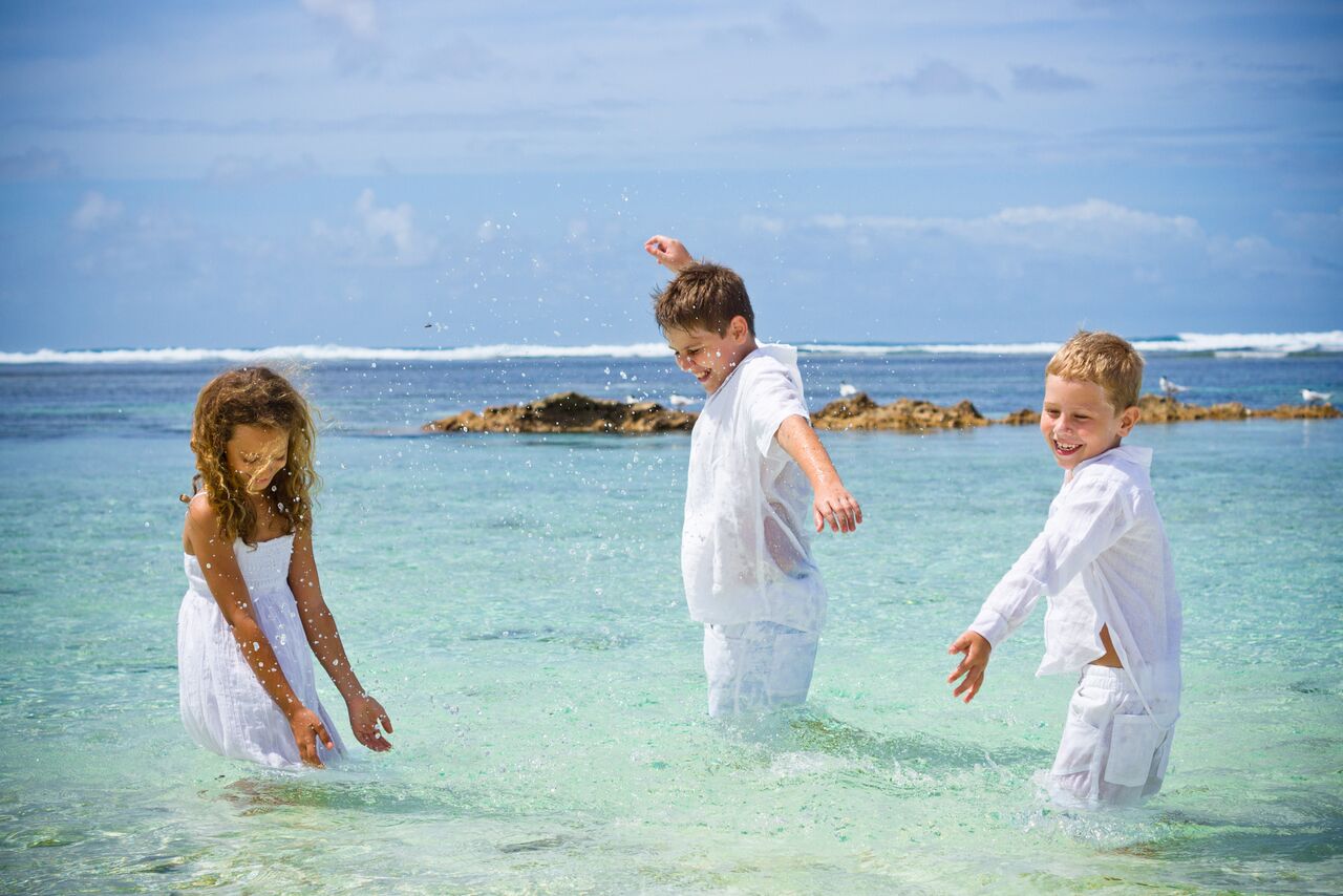 Three children having fun in the ocean in the Seychelles | Just Seychelles