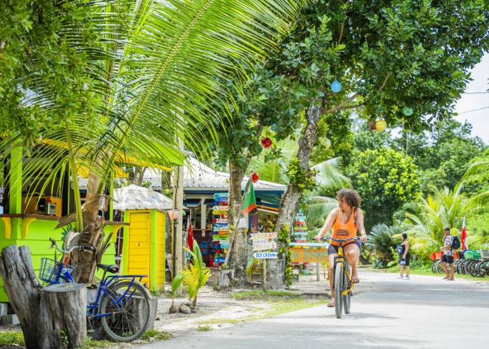 Woman cycling through La Digue | Just Seychelles