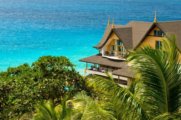 Exterior of Patatran Village Hotel, La Digue with ocean in the background | Just Seychelles