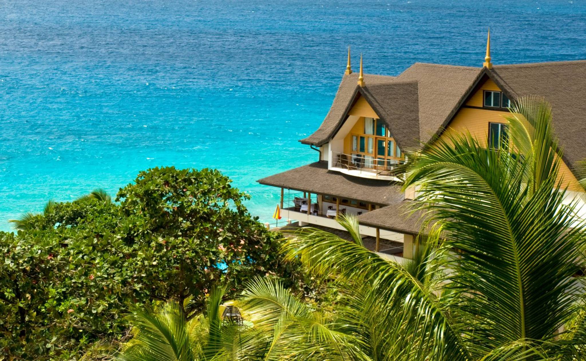 Exterior of Patatran Village Hotel, La Digue with ocean in the background | Just Seychelles